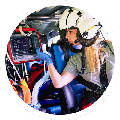 Notärztin der DRF Luftrettung bedient ein Beatmungsgerät im Rettungshubschrauber.